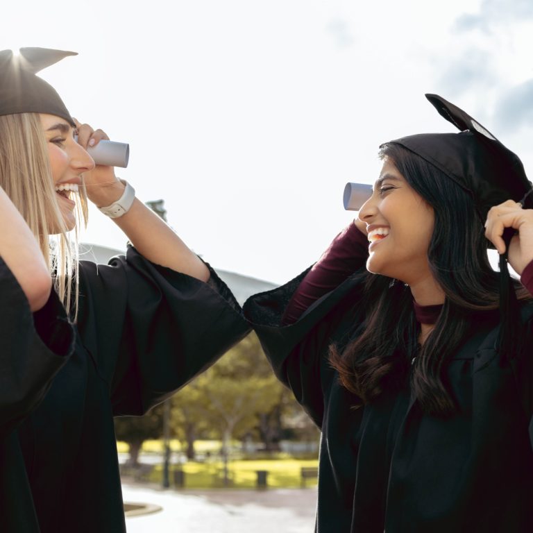 Graduate women, friends and smile together with graduation cap, congratulations and success for studying. University student, gen z girl and excited with diversity, goal and happiness for achievement
