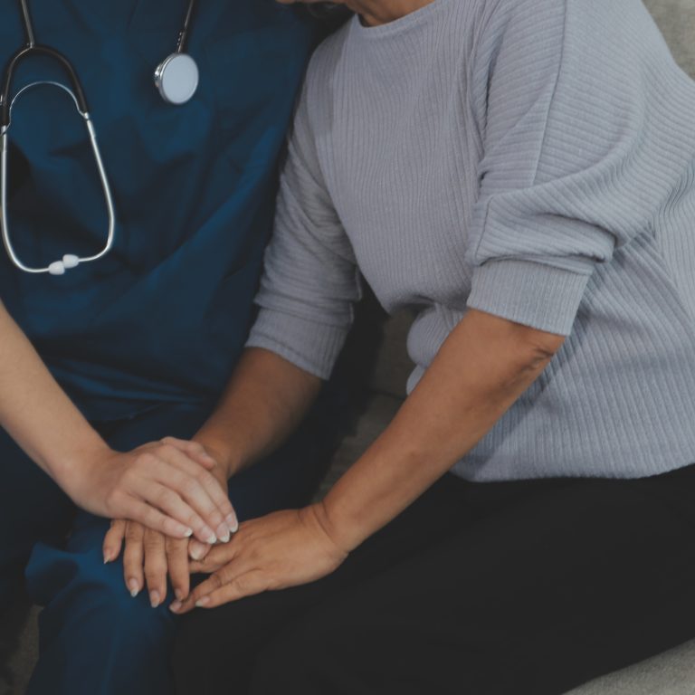 Female caregiver doing regular check-up of senior woman in her home.