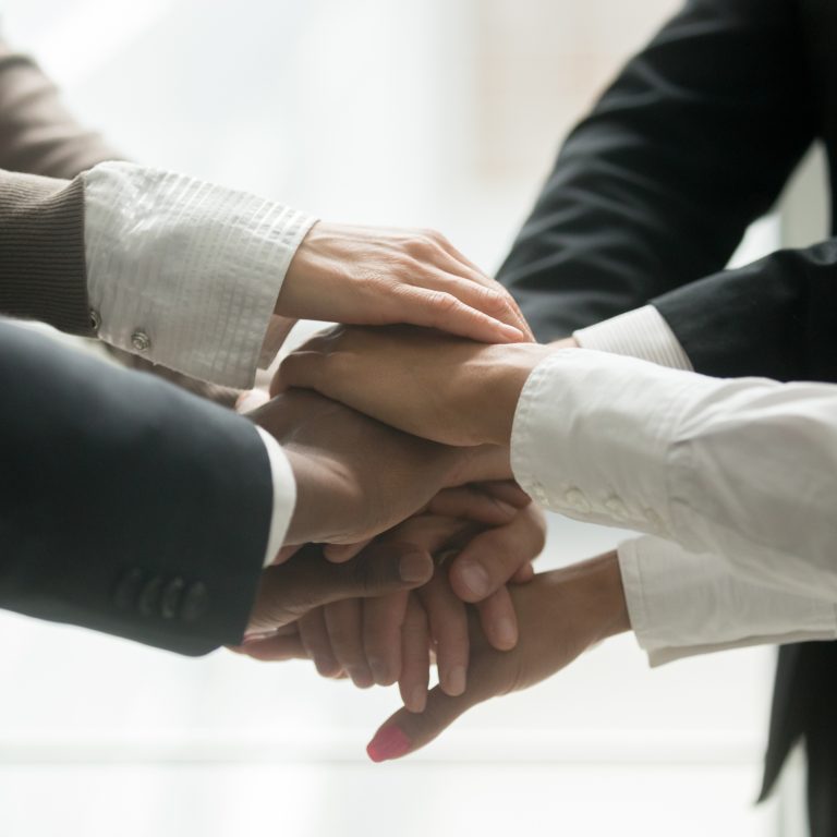 Diverse multiracial business team holding stacked pile of hands together promising help loyalty support, engaging in teambuilding, united at motivating training, coaching concept, close up view